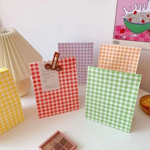 Detailed close-up of colorful plaid gift bags with vintage clip and decorative card