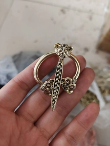 Detail of vintage gold Viking brooch featuring three owl heads and sword element