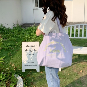 Close-up of lilac canvas tote bag featuring yellow artistic PARIS embroidery detail