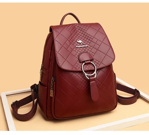 Détail d'un sac à dos bordeaux en cuir à losanges avec logo kangourou métallique chic