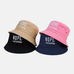 Detailed stack of cotton bucket hats with 'NOPE.' embroidery and metal ventilation eyelets
