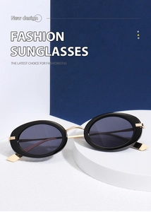 Detail of vintage oval sunglasses with black frames and gold metal temples on a pedestal