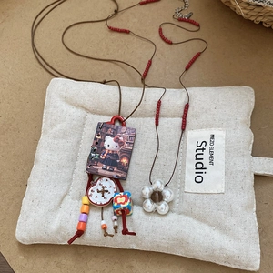Close-up of Hello Kitty pendant necklace with flower charm and beads on display tray