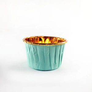 Macro-opname van mintgroene muffinbakjes met opgerolde rand en gouden metalen voering
