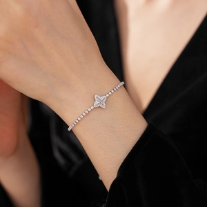 Macro view of adjustable silver clover bracelet with zircon flower and tennis chain