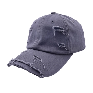 Détails de la casquette de baseball gris foncé avec des trous usés et des bords effilochés