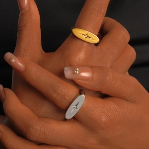 Detail showing stacked gold and silver starburst rings with small zircon on the model