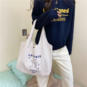 Détail du sac fourre-tout en toile blanche avec boucle magnétique et motif lapin bleu