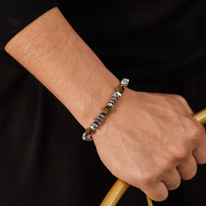 Detail of silver beads and brown tiger eye stone bracelet on wrist with gold accent