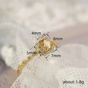 Elegant gold-tone square crystal ring with milgrain detailing and sparkling micro-pave