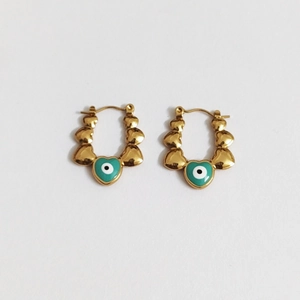 Elegant gold stainless steel heart earrings with green evil eye charms on white background