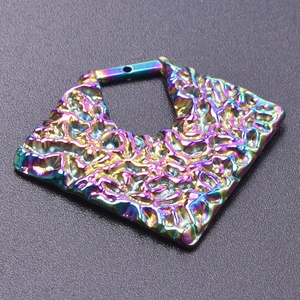 Macro view of geometric pendant with hammered texture and colorful rainbow plating
