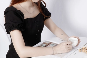 Silver curb chain necklace and bracelet set styled on a model with a black dress
