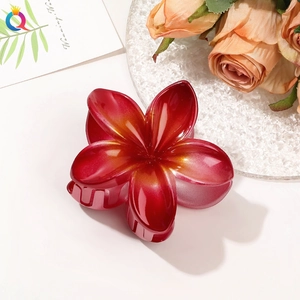 Macro shot of red gradient plumeria hair claw clip with elegant floral petal details