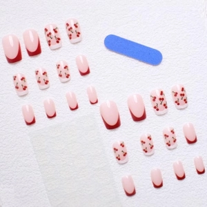 Short square press-on nails with red French tips and cute cherry patterns with a nail file