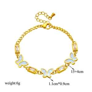 Golden butterfly bracelet with white shell charm and crystals on white background