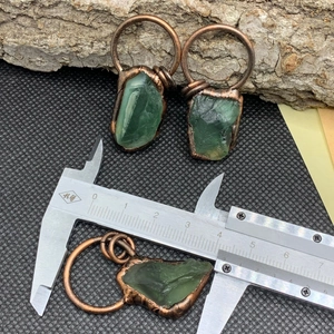 Vista dettagliata di pendenti in fluorite grezza con filo di bronzo e misure del prodotto