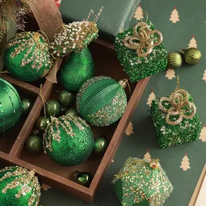 Green flocked Christmas ball ornaments set with gold glitter and pearls on a wooden tray