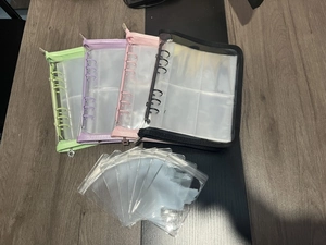 Detailed view of four transparent jewelry storage binders in green, purple, pink and black