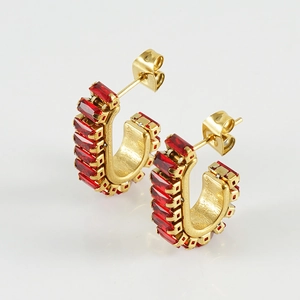 Detail of gold C-shape hoop earrings with rectangular red zircon stones on white background