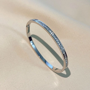 Minimalist silver titanium steel bangle with sparkling square zircons on beige silk