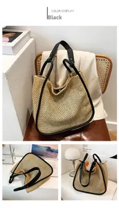 Close-up of beige woven straw tote bag with black trim detailing and metallic hardware