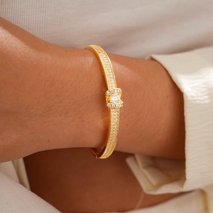 Detailed close-up of 18K gold plated clasp bangle with sparkling zircon stones on wrist