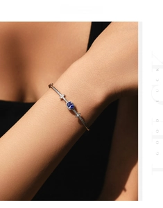 Detailed shot of an S925 silver bracelet with an oval blue gemstone and pave diamonds