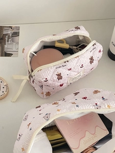 Gros plan sur la trousse à maquillage rose matelassée avec motif ours et fermeture