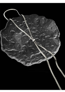 Detail of silver snake chain necklace with adjustable sliding buckle on textured glass