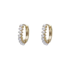 Elegant gold hoop earrings featuring a row of delicate white pearls on a white background