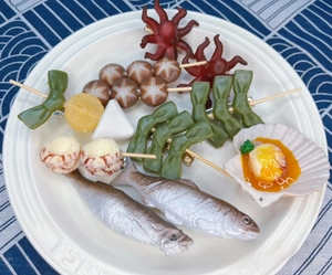 Detailed close-up of creative realistic food hair clips on a white ceramic plate