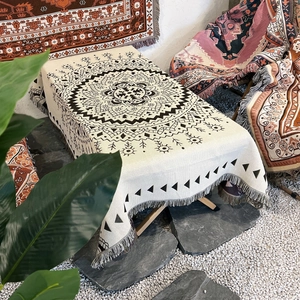 Detail of bohemian outdoor camping blanket featuring mandala patterns and tassel edges