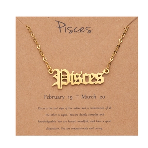 Detailed view of gold plated Pisces zodiac necklace on a decorative Kraft paper gift card