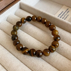 Macro detail of natural tiger eye stone beads bracelet in beige velvet jewelry box