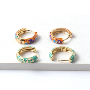 Vintage gold hoop earrings with colorful floral enamel patterns on a white display