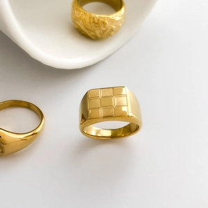 Top view of gold square signet ring with a 3x3 grid texture on a white background