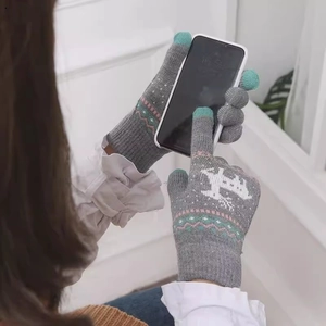 Gray touch screen knit gloves with elk pattern being used on a smartphone indoors