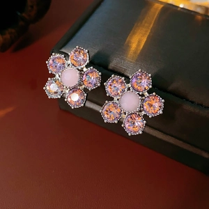 Vue macro de boucles d'oreilles fleurs en argent avec zircons lavande et pierre rose