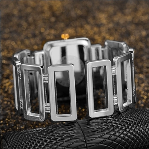 Macro shot of silver metal bracelet watch with hollow rectangular links and square dial