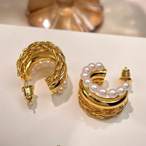 Three-layer 18K gold-plated braided hoop earrings with elegant pearls on beige surface