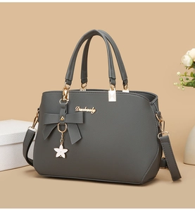 Close-up of dark grey crossbody bag with lychee texture and metal star pendant