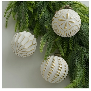 Close-up of white and gold patterned 8cm Christmas ball ornaments on pine branches