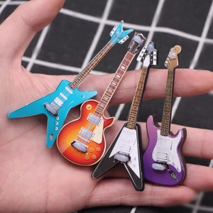 Miniature dollhouse electric guitar models in four colors held in hand for scale