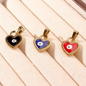 Three gold heart pendants with evil eye enamel in black blue and red on velvet