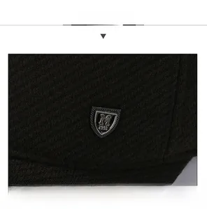 Macro view of a black winter baseball cap featuring a vintage metal shield emblem with M 1991