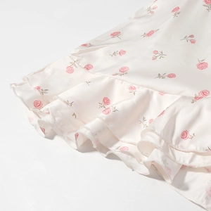 Robe fleurie en satin élégante avec base crème, roses roses et ourlet à volants étagés