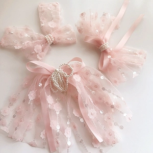Detailed close-up of pink lace bow hair clips with pearls and sequins for girls