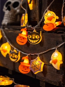 Halloween LED string lights with pumpkin and ghost shapes hanging on a vintage wooden box