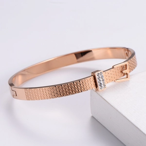 Close-up of rose gold belt buckle bracelet with sparkling rhinestones and metal finish